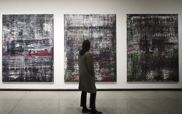 Des visiteurs devant la série « Birkenau » à la nouvelle exposition de l'artiste allemand Gerhard Richter à la Nouvelle Galerie nationale de Berlin, en Allemagne, le 31 mars 2023. (Crédit : AP Photo/Markus Schreiber)