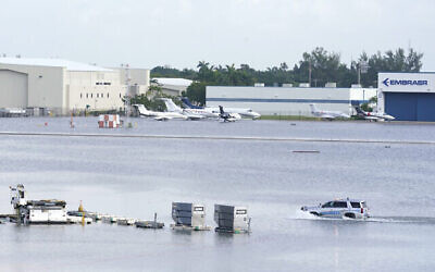 Un camion se déplace sur la piste inondée de l'aéroport international de Fort Lauderdale- Hollywood, le 13 avril 2023, à Fort Lauderdale, en Floride. (Crédit : AP Photo/Marta Lavandier)