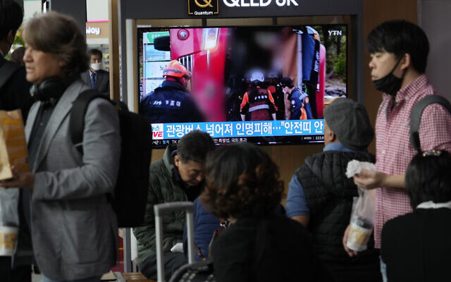 Un écran de télévision montrant une image d'un bus touristique renversé pendant un journal télévisé, à la gare de Séoul à Séoul, en Corée du Sud, le 14 avril 2023. (Crédit : AP Photo/Ahn Young-joon)