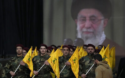 Des combattants du Hezbollah défilant devant une affiche représentant le guide suprême, l'ayatollah Khamenei, lors d'un rassemblement à l'occasion de la Journée d'Al-Qods, dans la banlieue sud de Beyrouth, au Liban, le 14 avril 2023. (Crédit : Hussein Malla/AP Photo)