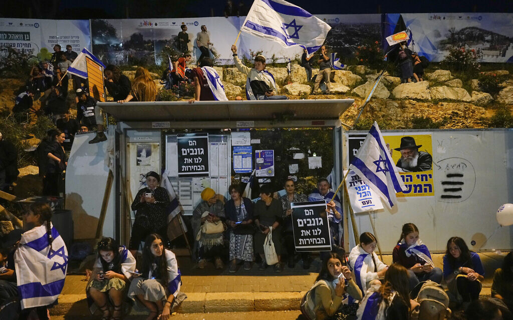 Des Israéliens de droite lors d'un rassemblement en soutien au projet de réforme judiciaire du Premier ministre Benjamin Netanyahu, aux abords de la Knesset, le 27 avril 2023. (Crédit : AP Photo/Ohad Zwigenberg)