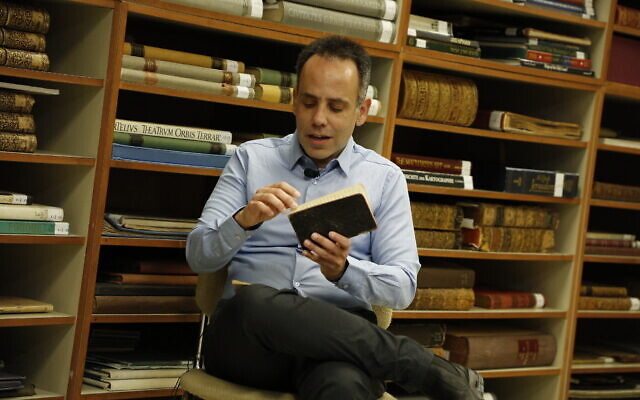 Amir Livnat avec "Le journal d'Avraham Weiss Livnat", qui fait partie de l'opération "Journal de bord : La génération fondatrice", en l’honneur du 75e anniversaire d'Israël. (Crédit : Uri Bareket/Bibliothèque nationale d'Israël)