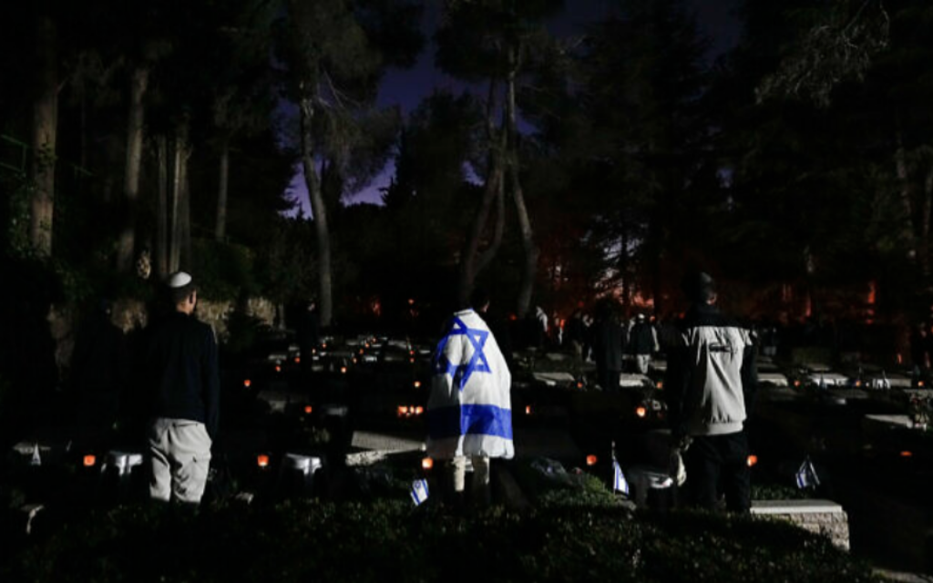 Des Israéliens visitant le cimetière militaire du mont Hertzl, à Jérusalem, le 24 avril 2023. (Crédit : AP Photo/Ohad Zwigenberg)