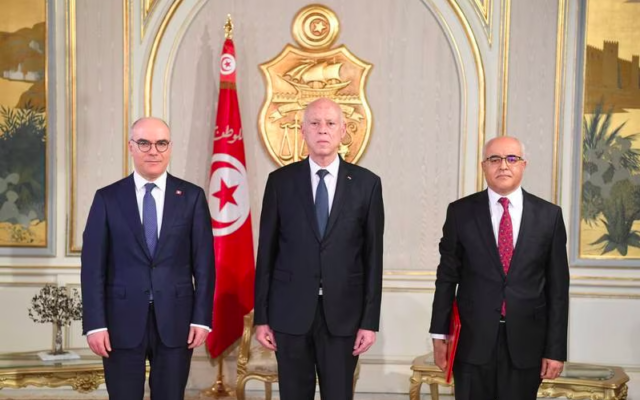 Le président tunisien Kais Saïed remettant ses lettres de créance à Mohamed Mhadhbi, le nouvel ambassadeur de Tunisie en Syrie, à droite, aux côtés du ministre des Affaires étrangères Nabil Ammar, à gauche. (Crédit : Bureau du président tunisien)
