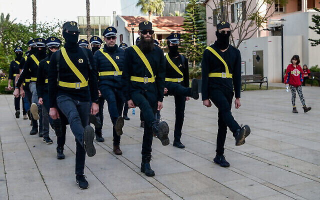 Des manifestants anti-gouvernement déguisés en membres de la garde nationale du ministre de la Sécurité intérieure, Itamar Ben Gvir, avant une manifestation contre la refonte judiciaire, à Tel Aviv, le 1er avril 2023. (Crédit : Avshalom Sassoni/Flash90)