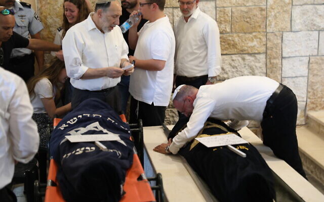 Le rabbin Leo Dee étreint les corps sans vie de ses filles, Maia et Rina Dee, avant leur inhumation à Kfar Etzion, le 9 avril 2023. (Crédit : Noam Revkin Fenton/FLASH90)