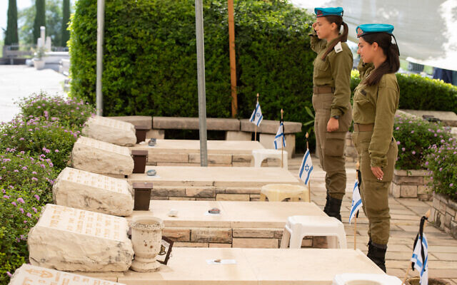 À l'approche de Yom HaZikaron, des soldats déposant des fleurs et des drapeaux sur les tombes des soldats israéliens tombés au combat dans le cimetière militaire de Kiryat Shmona, le 24 avril 2023. (Crédit : Ayal Margolin/ Flash90)