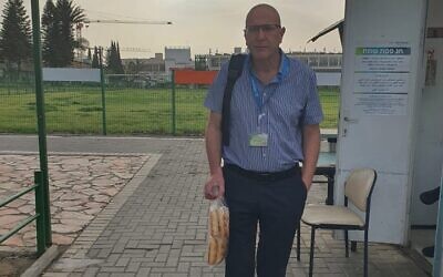 Gal Ifergane, directeur du service de neurologie, pose aux abords de l'hôpital Soroka de Beer Sheva avec les pains qu'il a amenés en défiance contre la loi sur le hametz, qui interdit l'entrée de produits alimentaires levés dans les établissements hospitaliers. (Crédit : Gal Ifergane, via Facebook)