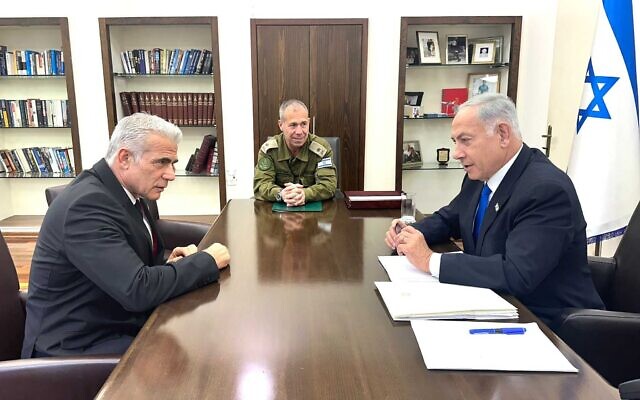 Yaïr Lapid, à gauche, Avi Gil, au centre, et Benjamin Netanyahu lors d'une réunion à la base militaire de Kirya, à Tel Aviv, le 9 avril 2023. (Crédit : Document du gouvernement)