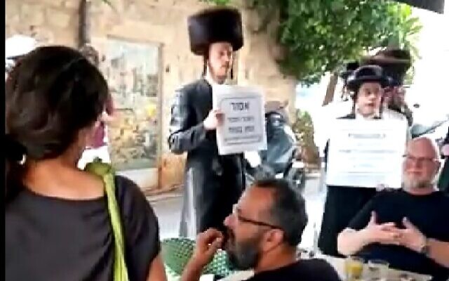 Des ultra-orthodoxes manifestent aux abords du restaurant Menza, à Jérusalem, le 10 avril 2023. (Capture d'écran : Twitter/Eran Ben Yehuda; used in accordance with Clause 27a of the Copyright Law)