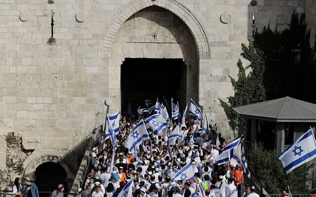 Des Juifs participant à la "Marche des drapeaux" à l'occasion de la Journée de Jérusalem, passent par la porte de Damas, dans la Vieille Ville de Jérusalem, le 29 mai 2022. (Crédit : Ahmad Gharabli/AFP)