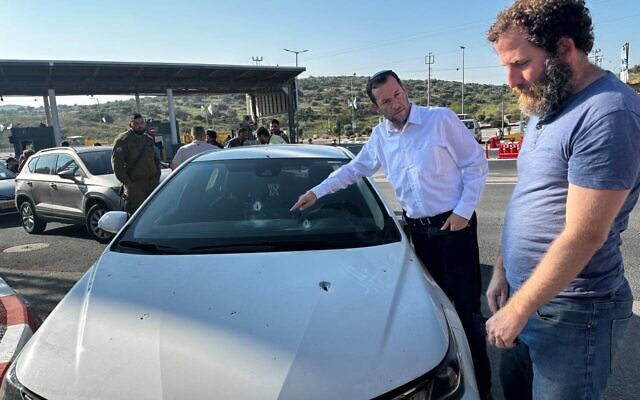 Le président du Conseil régional de Samarie, Yossi Dagan, inspectant les dommages causés à une voiture appartenant à un Israélien à la suite d'une fusillade près d'Avnei Hefetz dans le nord de la Cisjordanie, le 2 mai 2023. (Crédit : Sergei Kamshev/Conseil régional de Samarie)