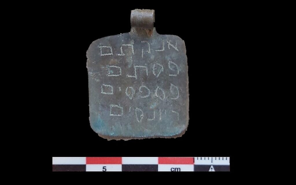 Une amulette portant un nom mystique de Dieu gravé dans le métal, datant probablement de 100 à 200 ans, trouvée dans la synagogue de Tamanart, au Maroc, en novembre 2021. (Crédit : Autorisation d'Orit Ouaknine-Yekutieli/Yuval Yekutieli)