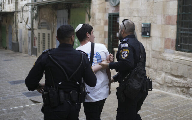 Des policiers arrêtent un jeune Israélien après que son groupe a scandé des slogans à l'entrée de l'enceinte de la mosquée Al Aqsa lors de la Marche annuelle des drapeaux dans la Vieille Ville de Jérusalem, le 18 mai 2023. Illustration : (Crédit : Maya Alleruzzo/AP)