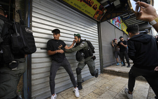 La police israélienne repousse des Palestiniens d'une rue du quartier musulman de la Vieille Ville de Jérusalem, peu avant une marche de nationalistes juifs dans le quartier, jeudi 18 mai 2023. (Crédit : Ohad Zwigenberg/AP)