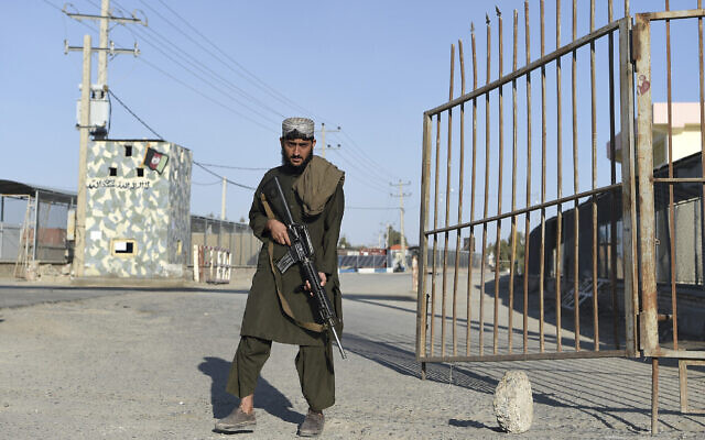 Un combattant taliban montant la garde à la porte d'entrée du pont frontalier entre l'Afghanistan et l'Iran, à Zaranj, le 18 février 2022. (Crédit : Wakil Kohsar/AFP)