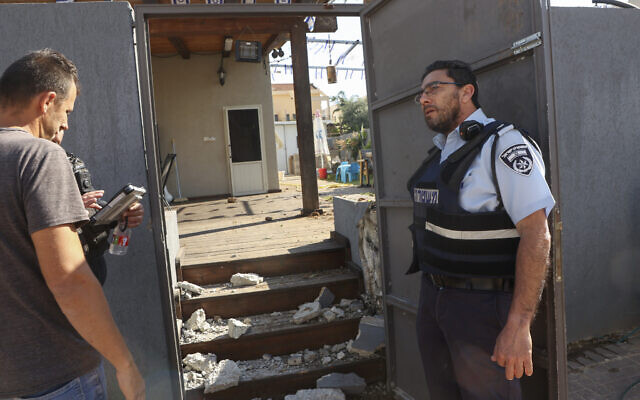 Les forces de sécurité israéliennes et le personnel d'urgence inspectent une maison endommagée dans la ville méridionale de Sderot après un tir de roquette depuis Gaza, le 2 mai 2023. (Crédit : GIL COHEN-MAGEN / AFP)