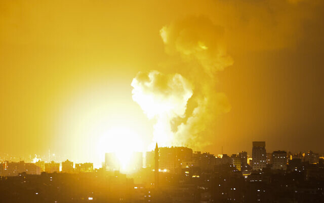 De la fumée s'élève au dessus des immeubles de Gaza City suite à une frappe aérienne, le 2 mai 2023. (Crédit : MOHAMMED ABED / AFP)