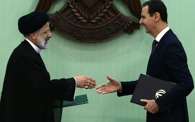 Le président syrien Bachar al-Assad (à droite) et son homologue iranien Ebrahim Raisi se serrent la main après avoir signé un protocole d'accord sur la "coopération stratégique à long terme" à Damas, le 3 mai 2023. (Crédit : LOUAI BESHARA / AFP)