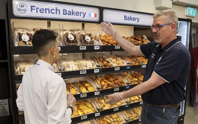 Les employés de l'hypermarché Carrefour dans la ville de Raanana se préparent à accueillir les clients le 9 mai 2023, alors que le groupe français inaugure 50 magasins à travers le pays. (Crédit : JACK GUEZ / AFP)