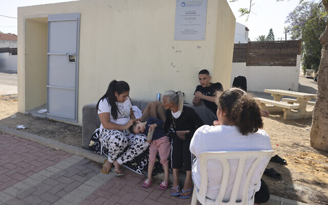 Des habitants de la ville d'Ashkelon, dans le sud d'Israël, assis devant un abri anti-bombes, alors que les tensions entre les terroristes palestiniens de la Bande de Gaza et Israël s'intensifient, le 10 mai 2023. (Crédit : Menahem Kahana/AFP)