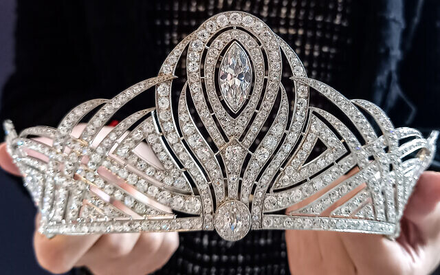 Un employé de la maison de vente aux enchères Christie's tenant le Bessborough Diamond Tiara, le 15 mai 2023, à Genève. (Crédit : Robin MILLARD / AFP)