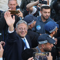 Le ministre de la Sécurité nationale, Itamar Ben Gvir, entouré d'officiers de police, salue les personnes rassemblées devant la porte de Damas menant à la Vieille Ville de Jérusalem, le 18 mai 2023. (Crédit : AHMAD GHARABLI / AFP)
