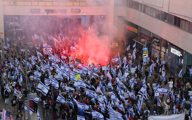 Des manifestants allumant des fusées éclairantes lors d'une manifestation contre le projet de loi de réforme du système judiciaire du gouvernement, à Tel Aviv, le 20 mai 2023. (Crédit : Ahmad Gharabli/AFP)