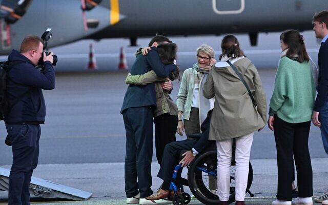 Le travailleur humanitaire belge libéré Olivier Vandecasteele (G) embrasse les membres de sa famille alors qu'il débarque d'un avion sur le tarmac lors de son retour en Belgique après près de 15 mois de captivité en Iran, à l'aéroport militaire de Melsbroek, au nord de Bruxelles, le 26 mai 2023. (Crédit : Didier LEBRUN / AFP)