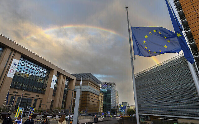Le drapeau de l'Union européenne est en berne alors qu'un double arc-en-ciel se forme au-dessus du bâtiment du Conseil européen à Bruxelles, le 9 septembre 2022. (Crédit : AP Photo/Olivier Matthys)