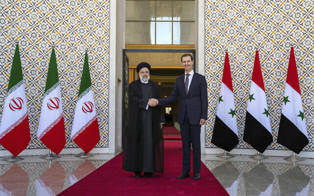 Le président syrien Bashar al-Assad, à droite, serre la main au président iranien  Ebrahim Raisi à Damas, en Syrie, le 3 mai 2022. (Crédit : Présidence syrienne via Facebook via AP)