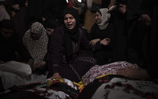 Ses proches pleurent la mort du commandant du Jihad islamique Khalil Bahtini, de sa femme et de son fils, tués lors d’une frappe aérienne israélienne à leur domicile de Gaza, le 9 mai 2023. (Crédit : AP Photo/Fatima Shbair)