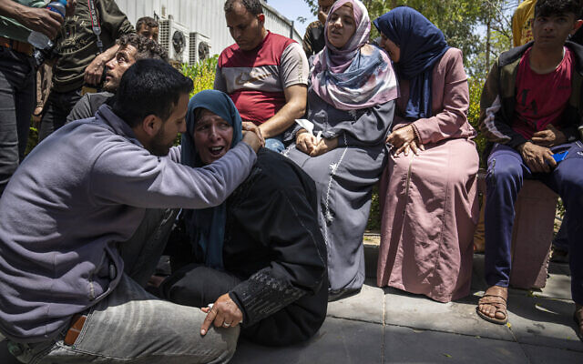 Les Palestiniens pleurant Mohammed Abu Taima, tué lors d'une frappe aérienne israélienne, à Khan Younis dans la Bande de Gaza, le 10 mai 2023. (Crédit : AP Photo/Fatima Shbair)