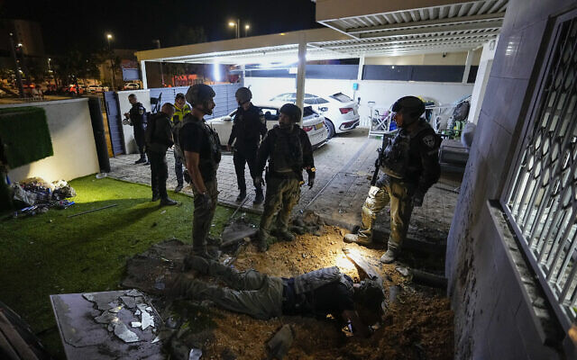 Des policiers inspectent une maison touchée par une roquette tirée depuis la bande de Gaza, à Sderot, dans le sud d'Israël, le 10 mai 2023. (Crédit : AP/Ohad Zwigenberg)