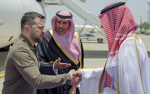 Le président ukrainien Volodymyr Zelensky, à gauche, accueilli par le prince Badr Ben Sultan, gouverneur adjoint de La Mecque, à son arrivée à l'aéroport de Jeddah pour assister au sommet de la Ligue arabe, en Arabie saoudite, le 19 mai 2023. (Crédit : Saudi Press Agency via AP)
