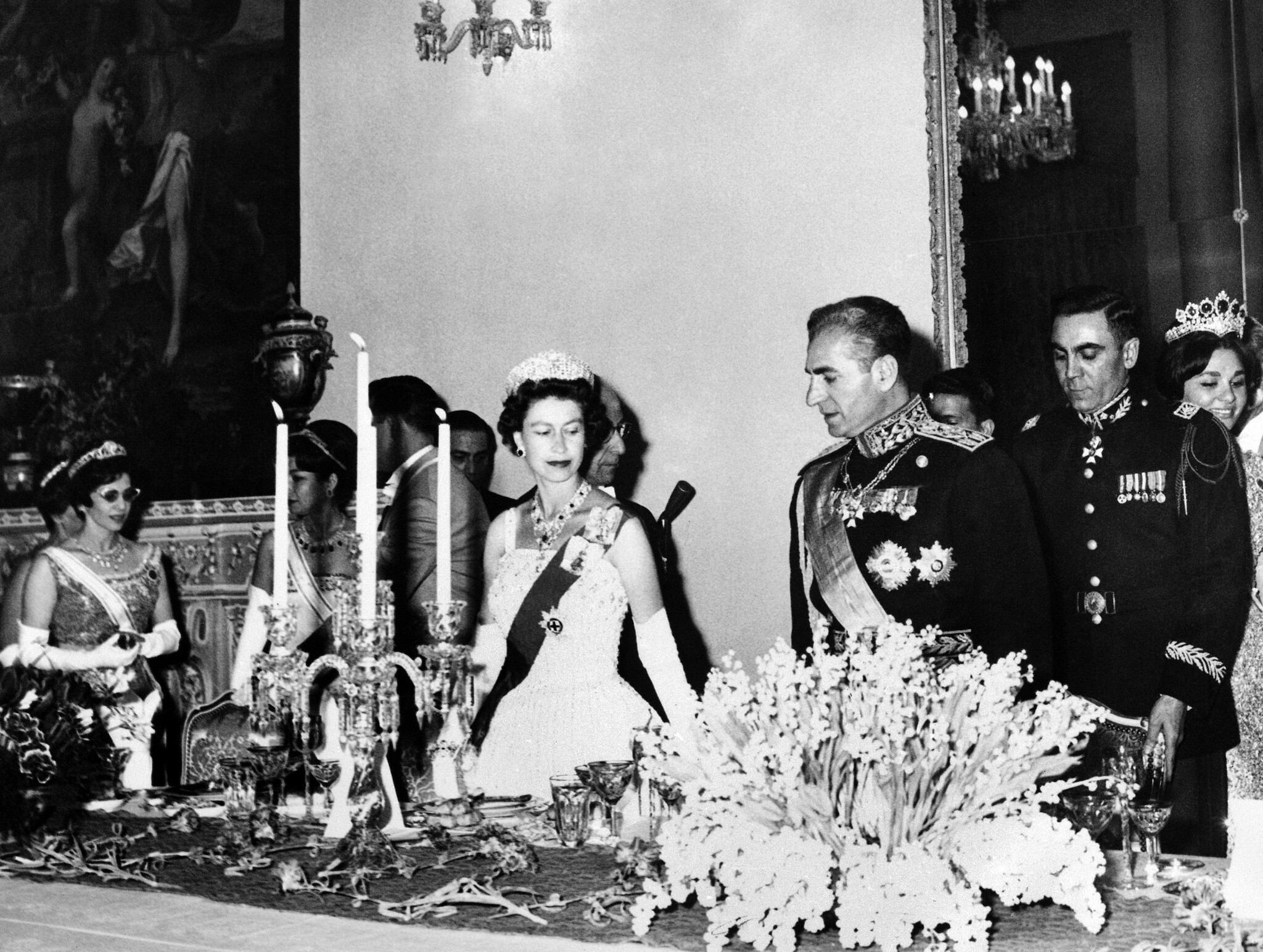 La Reine d'Angleterre Elizabeth II et le Shah d'Iran Reza Pahlevi lors d'un banquet offert en l'honneur de la souveraine au palais Golestan de Téhéran, en Iran, le 2 mars 1961. (Crédit : AP Photo)