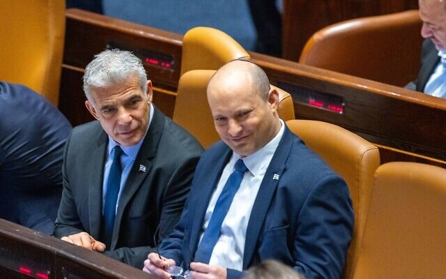 Le ministre des Affaires étrangères Yair Lapid (à gauche), le nouveau Premier ministre de transition, et le Premier ministre sortant Naftali Bennett (à droite) à la Knesset, lors du vote pour dissoudre le Parlement en vue de nouvelles élections, le 30 juin 2022. (Crédit : Olivier Fitoussi/Flash90)