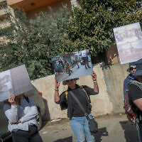 Des membres de l'ONG de gauche Breaking the Silence tenant des images montrant des abus commis par l'armée israélienne, lors d'une visite dans la ville de Hébron, en Cisjordanie, le 2 novembre 2022. (Crédit : Flash90)