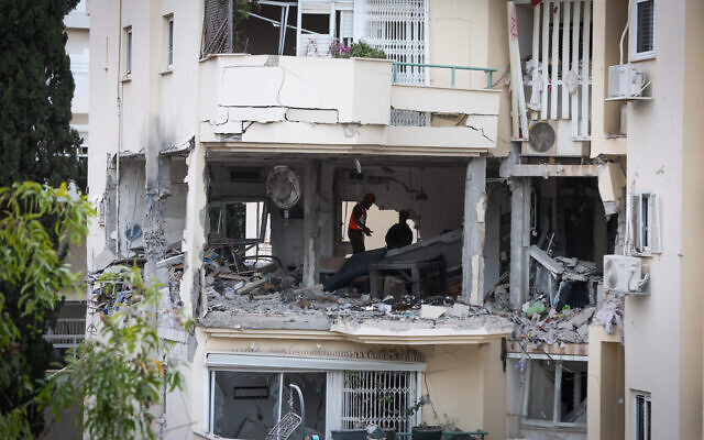 Police et secouristes sur les lieux où une roquette tirée depuis Gaza a touché et endommagé un bâtiment à Rehovot, le 11 mai 2023. (Crédit : Yossi Aloni/Flash90)