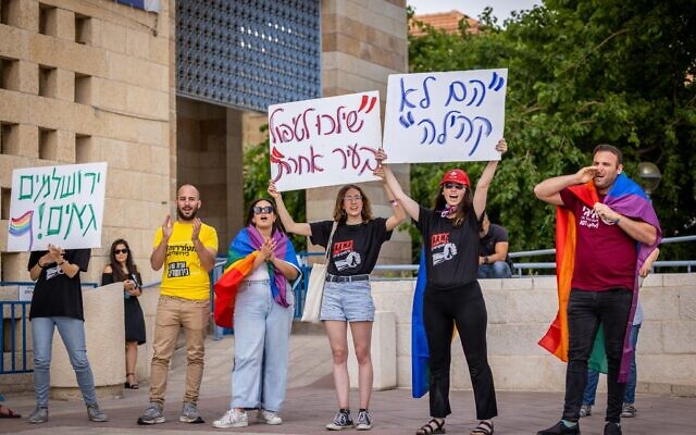Des membres de la communauté LGBTQ et leurs soutiens manifestent contre  Yonatan Yosef, membre du conseil municipal, devant la mairie de Jérusalem, le 22 mai 2023. (Crédit :  Yonatan Sindel/Flash90)