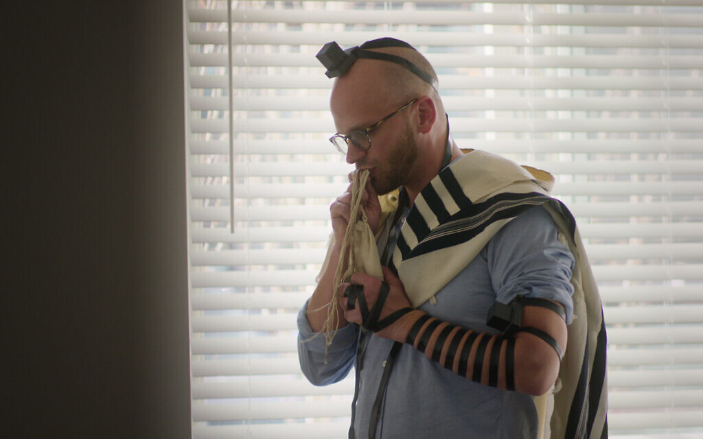 Noah, un participant à la série Netflix "Jewish Matchmaking", priant dans sa maison du Wyoming. (Crédit : Netflix)