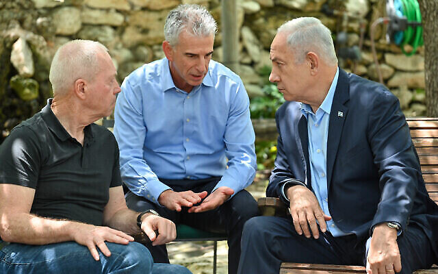 L Premier ministre Benjamin Netanyahu consulte le chef du Mossad David Barnea (C) et le ministre de la Défense Yoav Gallant (G) alors que ce dernier observe les sept jours de deuil après la mort de sa mère, le 12 mai 2023. (Crédit : Kobi Gideon/GPO)