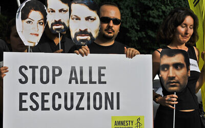 Des étudiants iraniens et des membres d'Amnesty International tiennent une banderole sur laquelle on peut lire "Stop aux exécutions" lors d'une manifestation devant l'ambassade d'Iran contre l'arrestation de dirigeants politiques lors des manifestations post-électorales à Téhéran en juin 2009. (Crédit : Andreas Solaro/AFP)