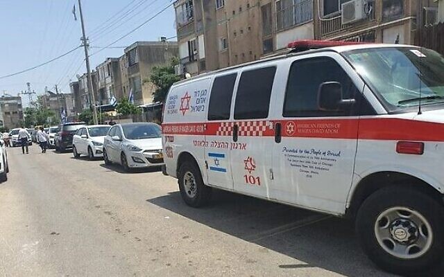 Une ambulance garée devant un immeuble ou une femme et son fils de 20 ans ont été retrouvés poignardés, à Netanya, le 12 mai 2023. (Crédit : Magen David Adom)