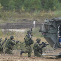 Des soldats canadiens participent aux exercices militaires de l'OTAN sur un terrain d'entraînement à Kadaga, en Lettonie, le 13 septembre 2021. (Crédit : Roman Koksarov/AP)