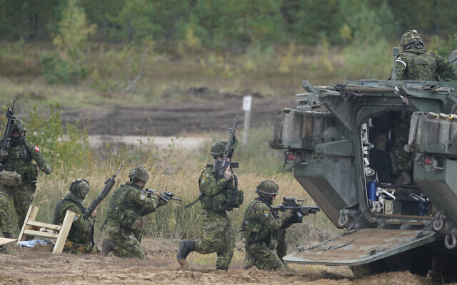 Des soldats canadiens participent aux exercices militaires de l'OTAN sur un terrain d'entraînement à Kadaga, en Lettonie, le 13 septembre 2021. (Crédit : Roman Koksarov/AP)