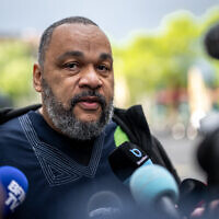 Le polémiste français Dieudonné M’Bala M’Bala au deuxième jour du procès de Tariq Ramadan au palais de justice de Genève, le 16 mai 2023. (Crédit : Fabrice COFFRINI / AFP)