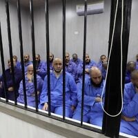 Des djihadistes accusés d'être membres du groupe État islamique (EI) sont assis dans la cabine de l'accusé pendant leur procès, dans la ville de Misrata, dans le nord-ouest de la Libye, le 29 mai 2023. (Crédit : Mahmud Turkia / AFP)