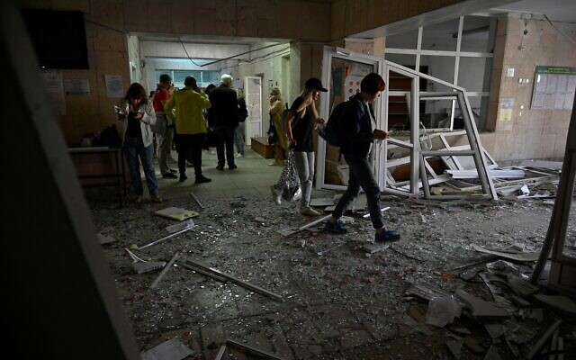 Des visiteurs traversant des débris dans le hall d'une clinique endommagée par l'explosion d'un missile à Kiev, le 1er juin 2023. (Crédit : Sergeï Chuzavkov/AFP)