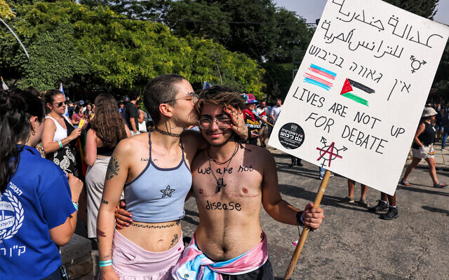Deux personnes s’embrassent lors de la 21e marche annuelle des fiertés à Jérusalem, le 1er juin 2023. (Crédit : Menahem KAHANA / AFP)